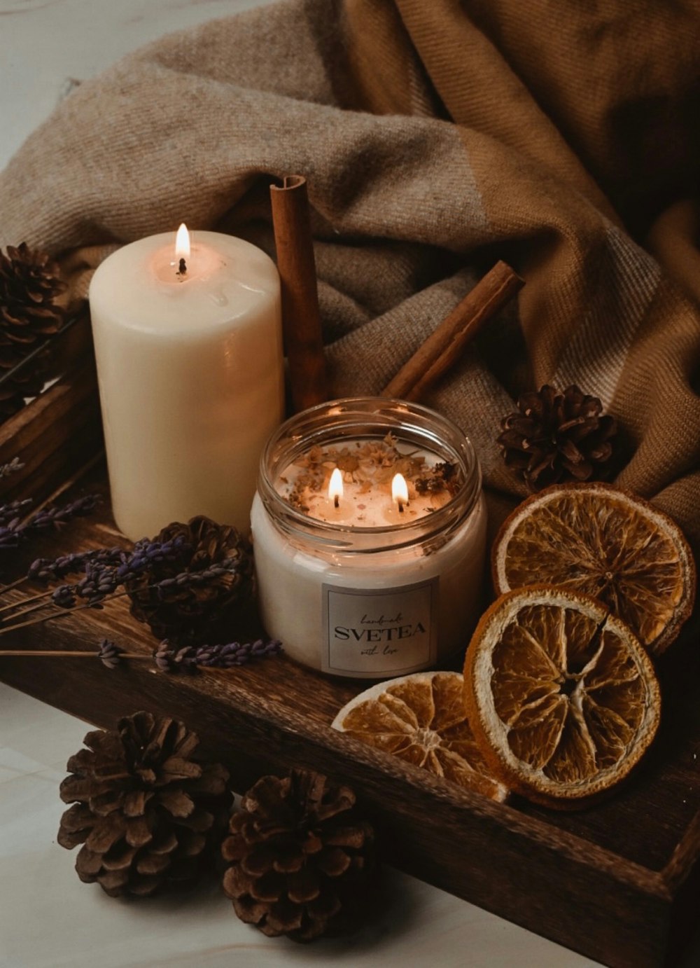 una candela seduta sopra un vassoio di legno