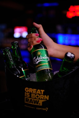 a woman holding a bottle of beer in a bucket