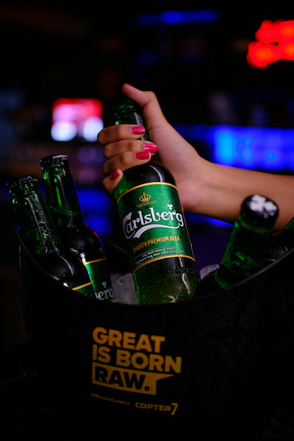 a woman holding a bottle of beer in a bucket