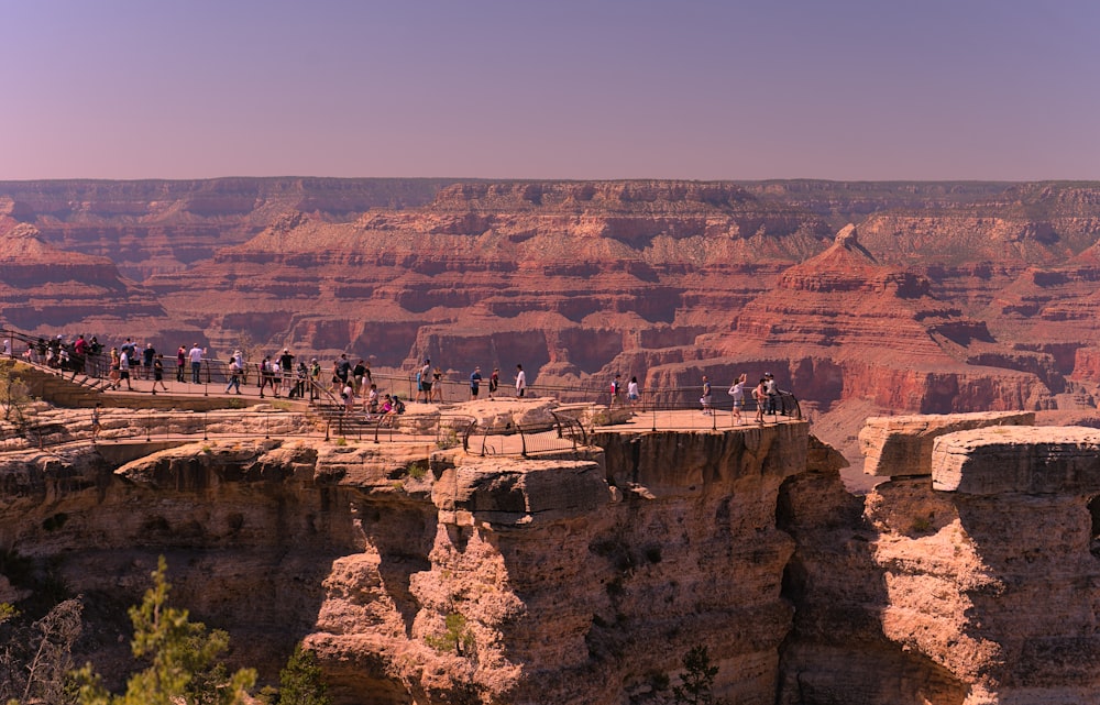 a group of people standing on the edge of a cliff