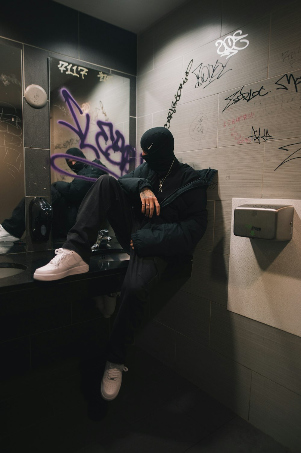 a man sitting on a counter in a bathroom