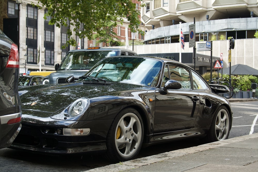 a black porsche parked on the side of the road