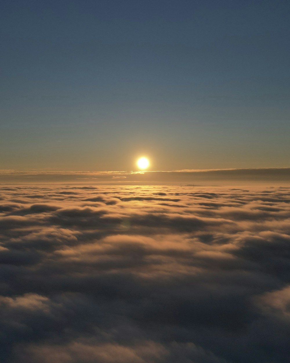 the sun is setting over the clouds in the sky