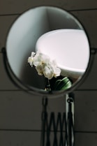 a mirror with a white flower in it
