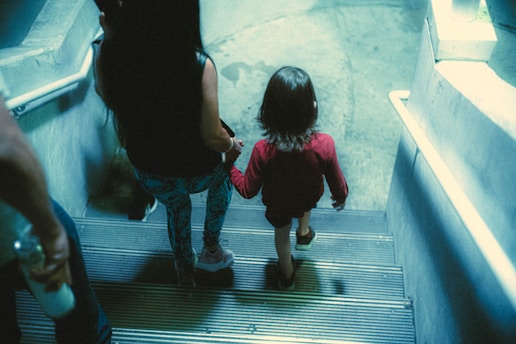 a little girl walking up a flight of stairs