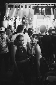 black and white photograph of two women standing in front of a crowd