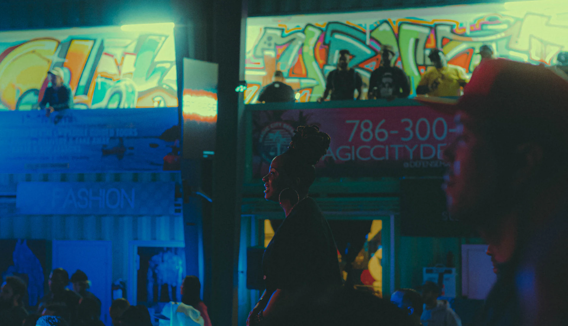 Urban street scene at night with graffiti walls and illuminated cityscape reflecting a dynamic music vibe.