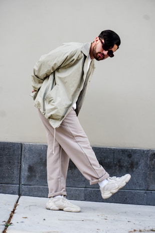 A casual street-style look featuring a male model in a modern beige jacket and white sneakers.