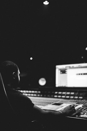 a man sitting in front of a mixing desk