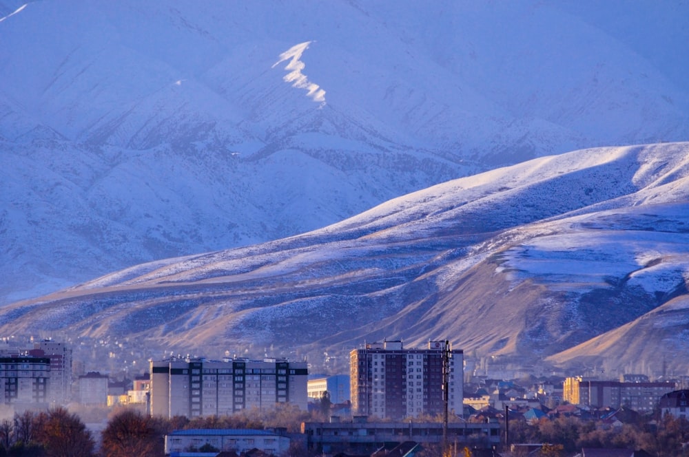 a snowy mountain with a city in the foreground