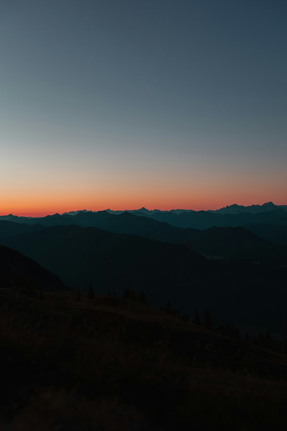 a person standing on top of a hill at sunset