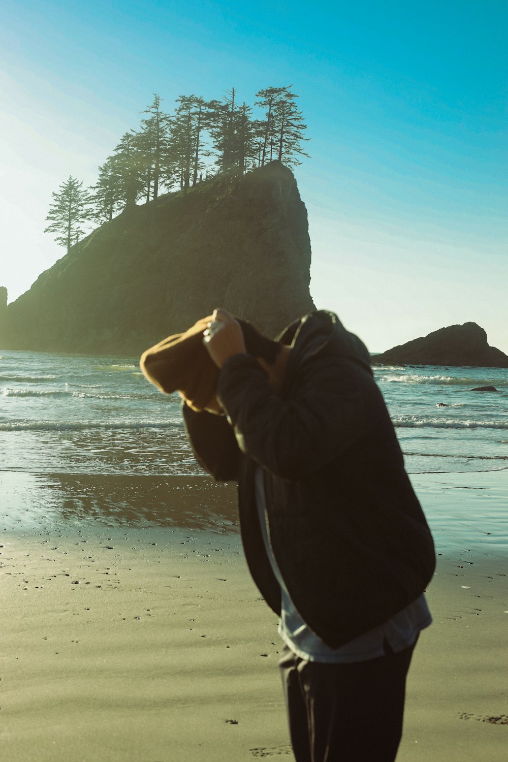 a man standing on top of a beach next to the ocean