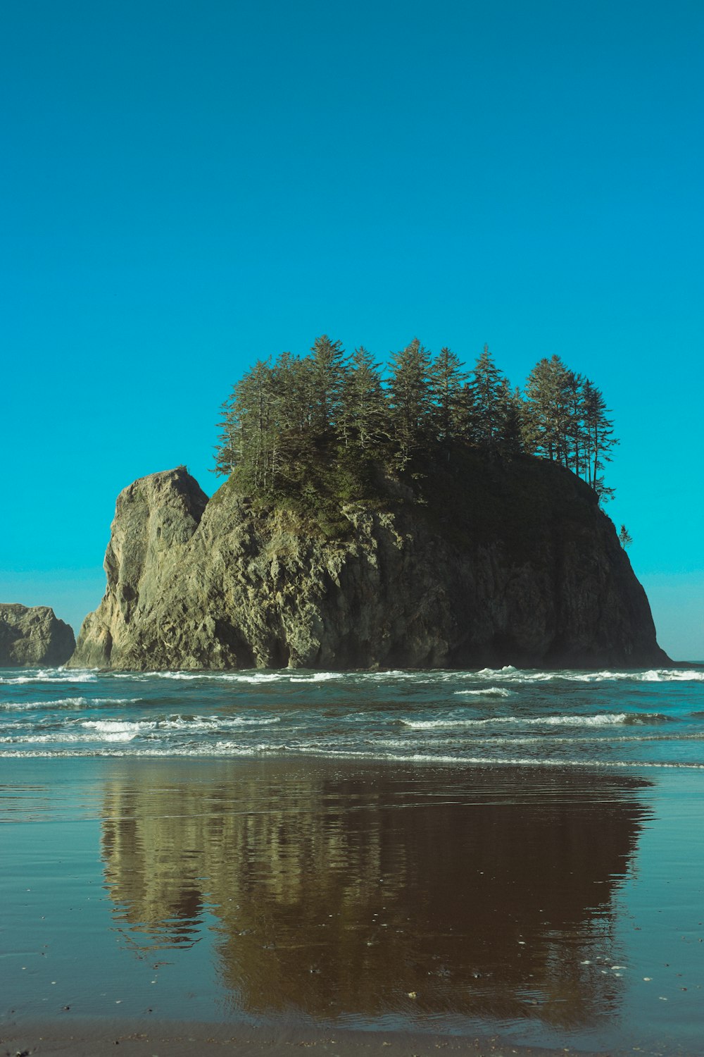 a large rock sitting on top of a sandy beach