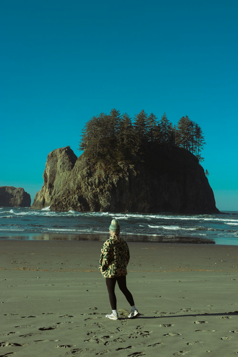 a woman standing on top of a sandy beach