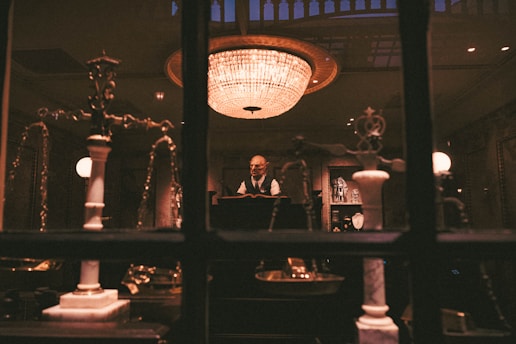 Elegant speaker confidently addressing a small audience under warm golden lighting.