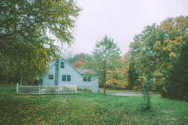 Cozy house with garden and white picket fence in a quiet neighborhood