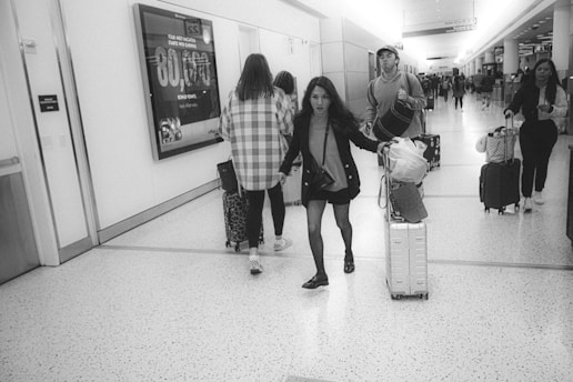 a group of people walking down a hallway with luggage