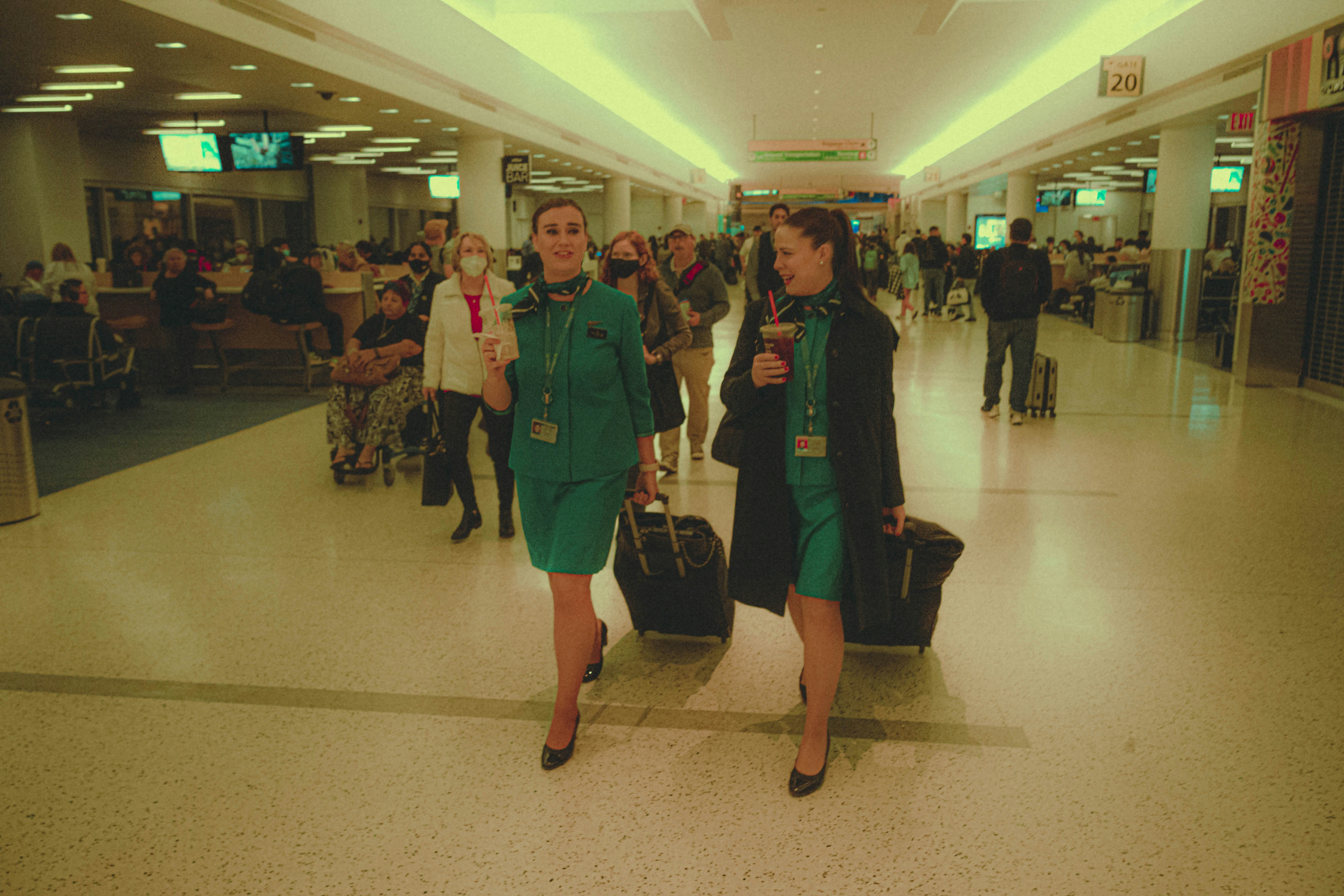 a couple of women walking through an airport, 
