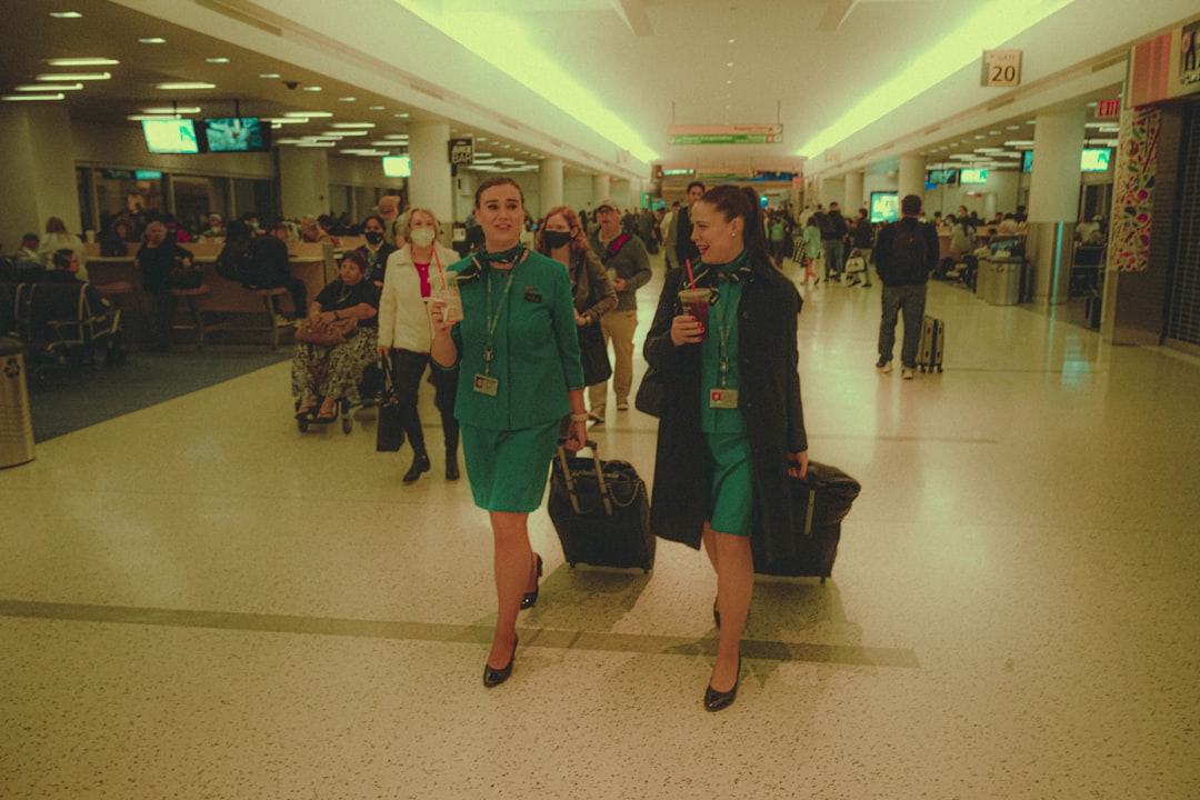 a couple of women walking through an airport,