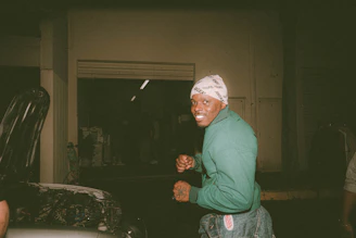 A smiling technician assisting a customer beside their car at dusk, with warm lighting.