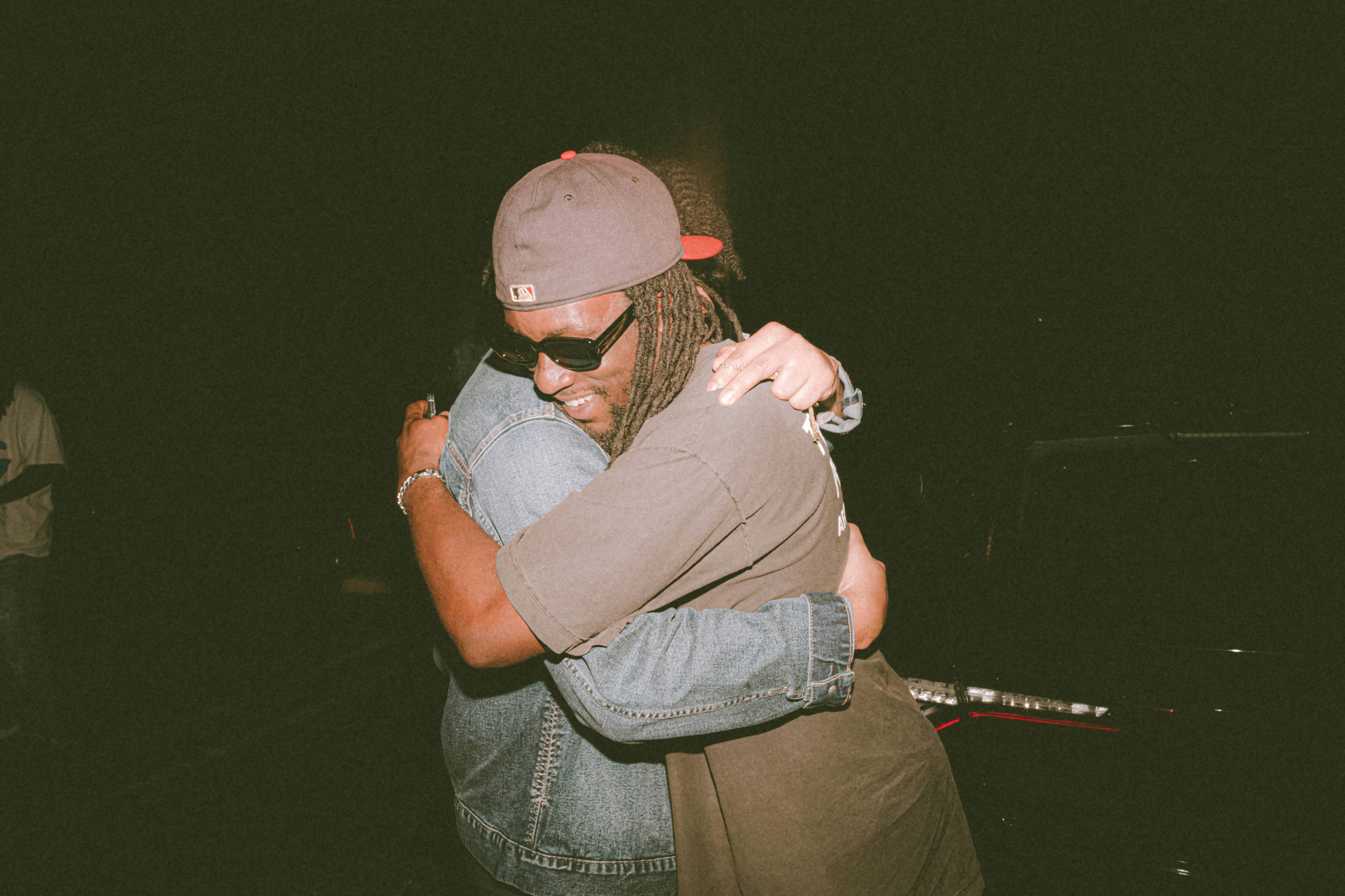 a man hugging another man in the dark