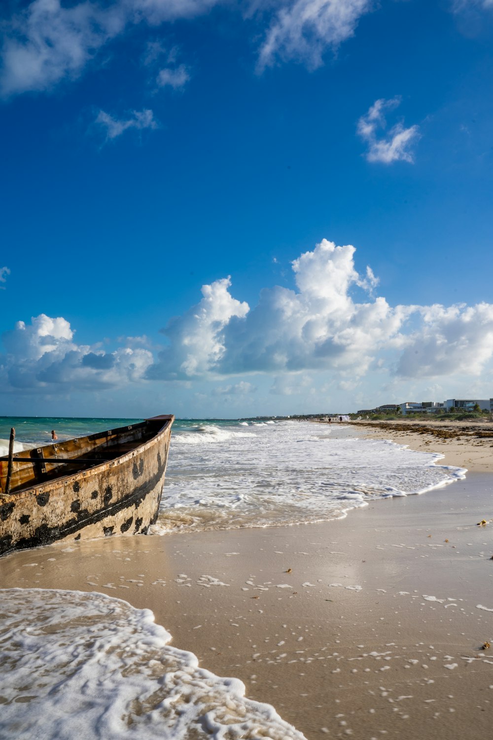 a boat sitting on top of a sandy beach