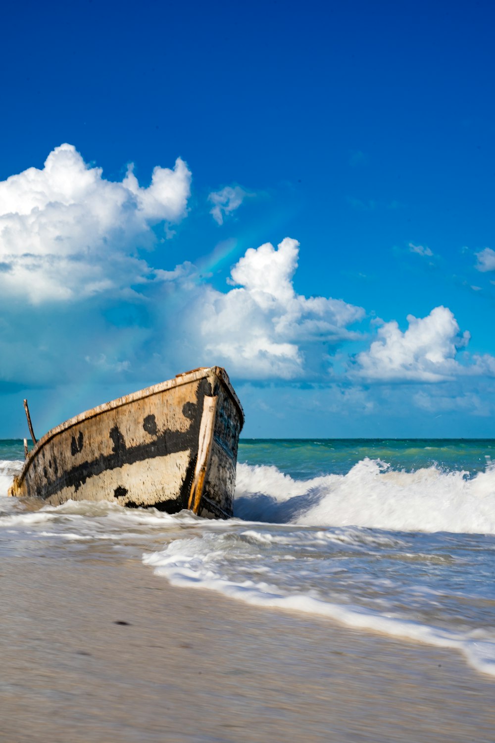 a boat sitting on top of a sandy beach