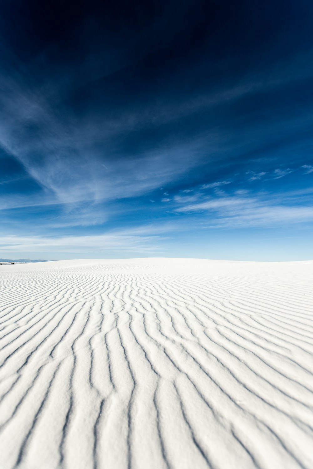 a wide expanse of white sand with a blue sky in the background