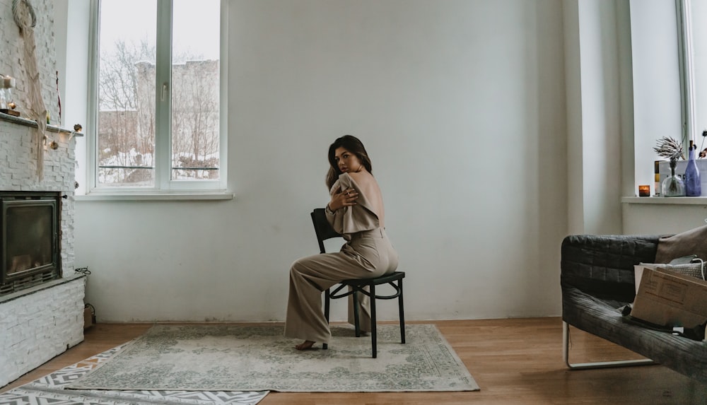 a woman sitting in a chair looking at her cell phone