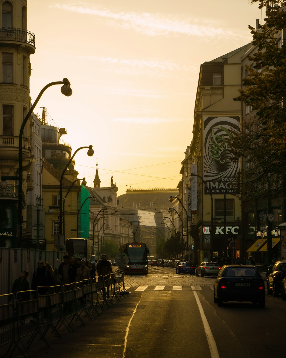 a city street at sunset with a bus on the road
