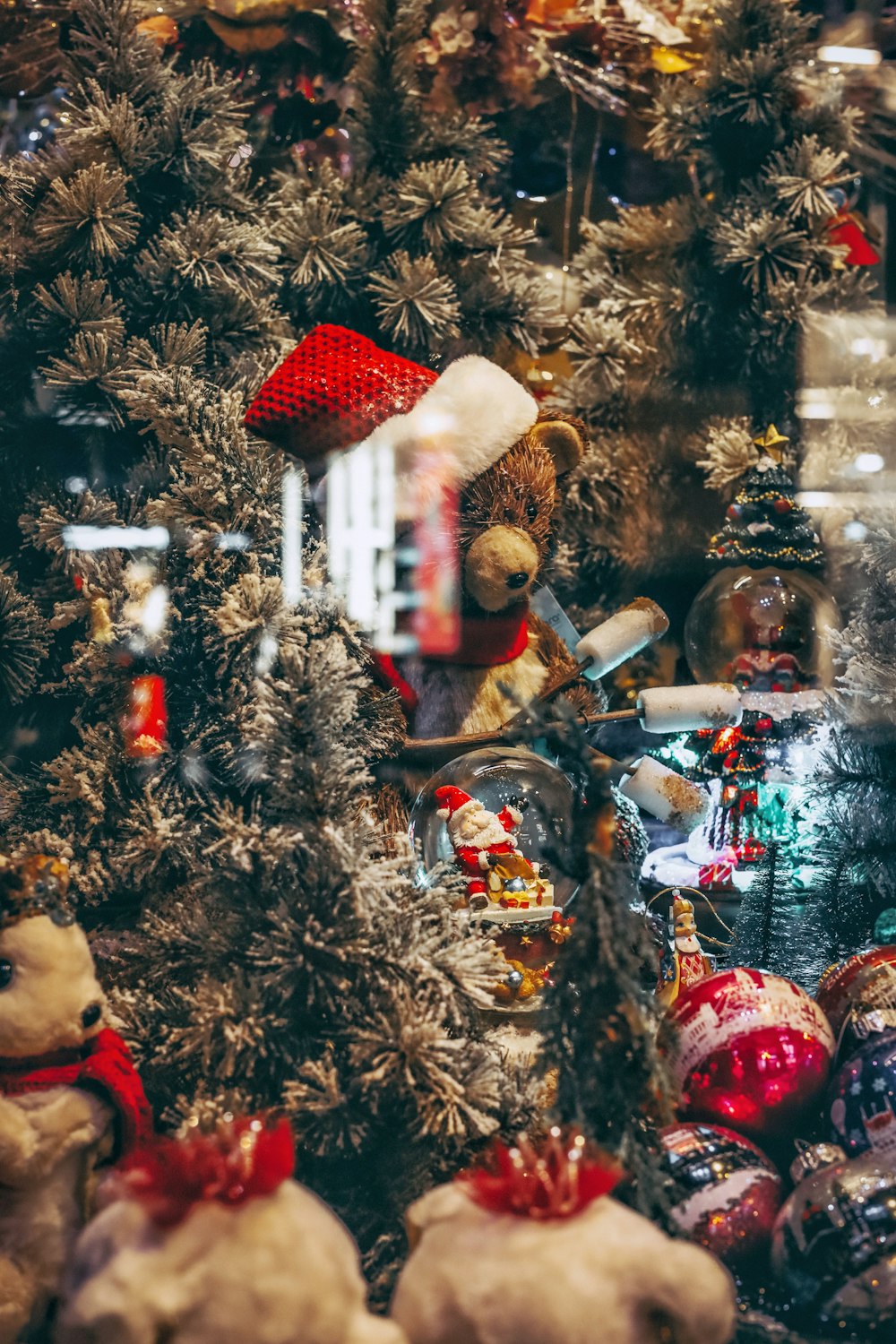 a teddy bear sitting on a bike next to a christmas tree