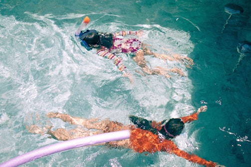 Guests enjoying the Divr+ virtual reality snorkeling experience at a sunny resort pool.
