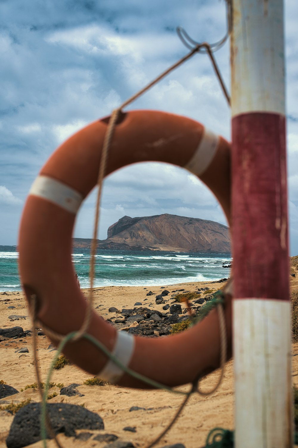 a life preserver hanging on a pole on a beach