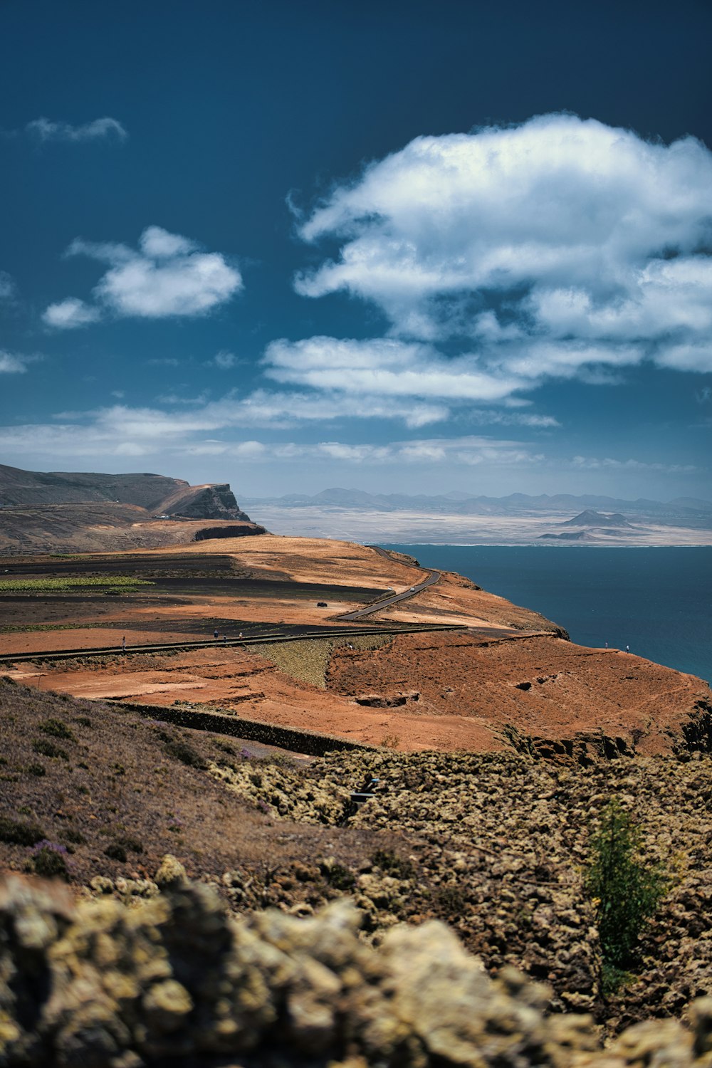 a large body of water sitting next to a rocky hillside