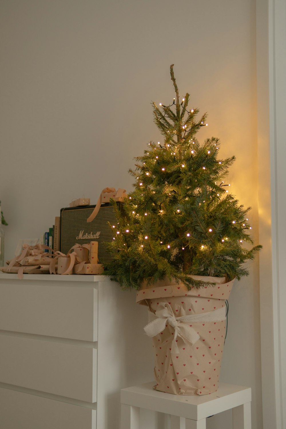 a small christmas tree sitting on top of a white dresser