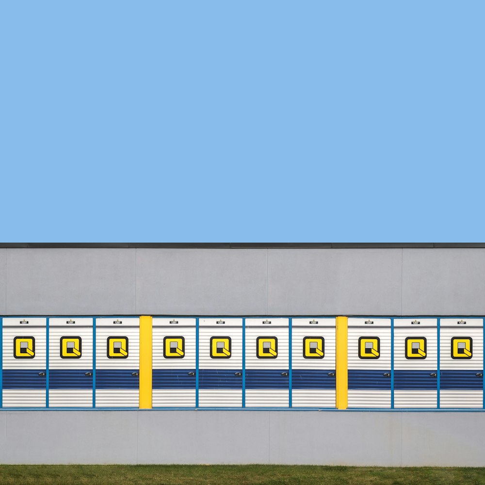 a yellow and blue train is on the side of a building