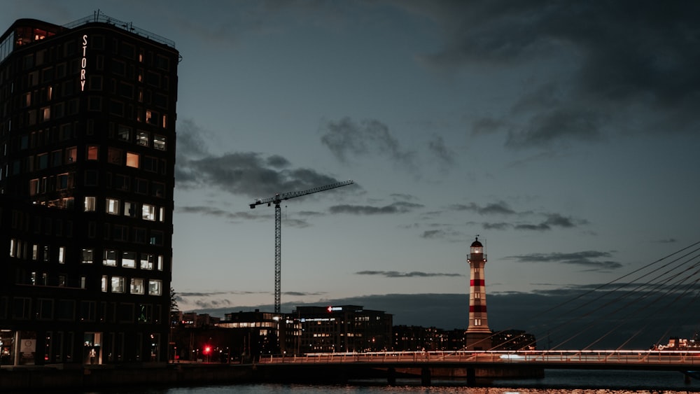 a tall building sitting next to a river under a cloudy sky