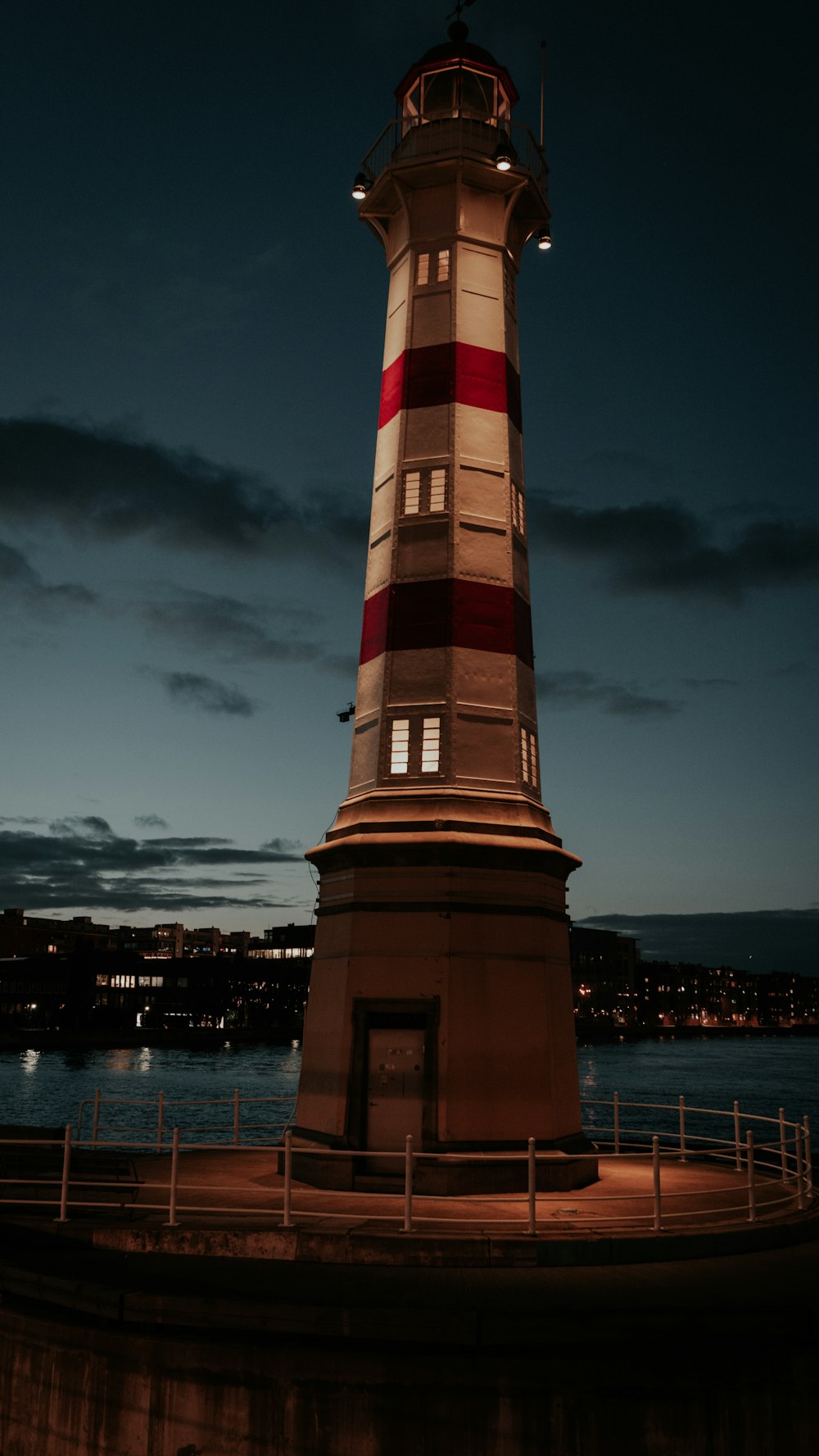 a red and white lighthouse sitting on top of a pier