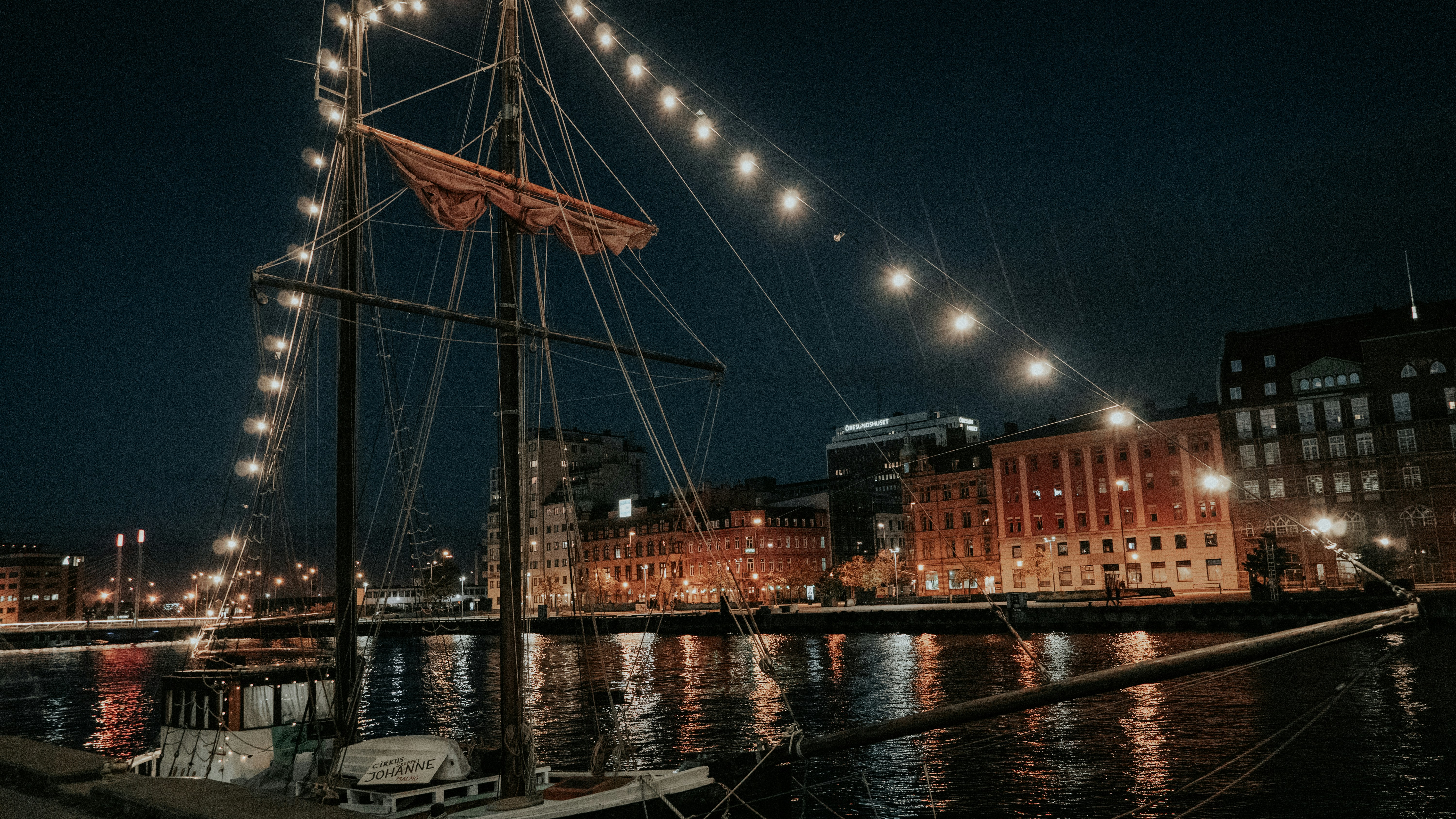 a boat is docked in a harbor at night