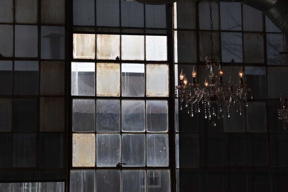 a chandelier hanging from a ceiling next to a window