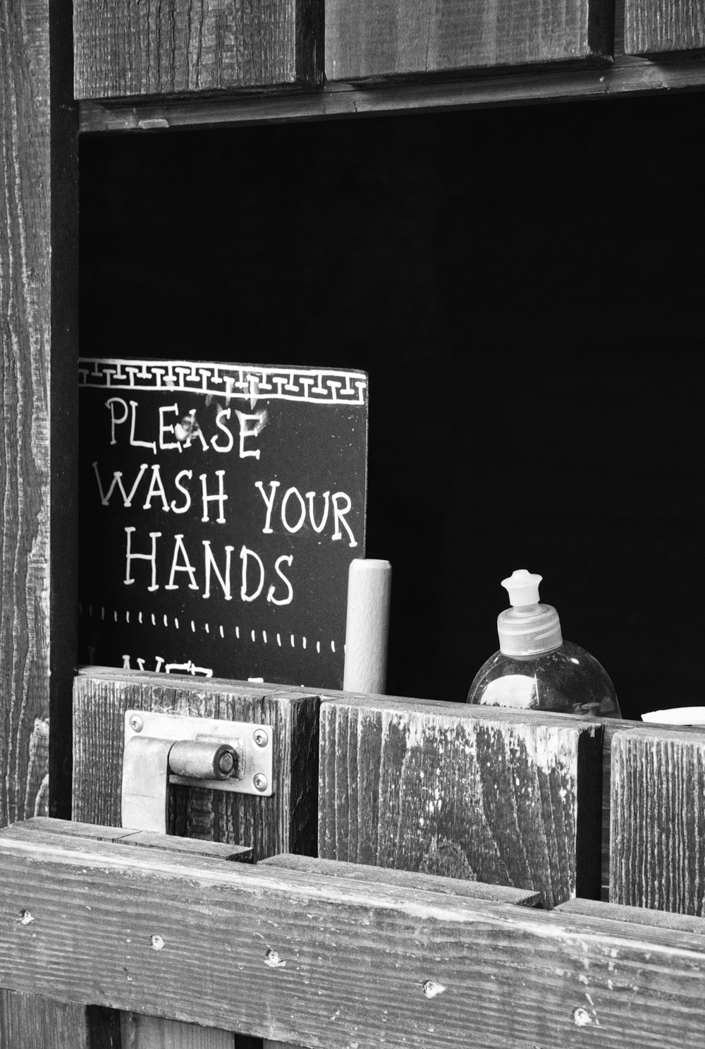 a black and white photo of a hand soap dispenser