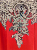 A finished embroidered patch with intricate gold threadwork on black material.