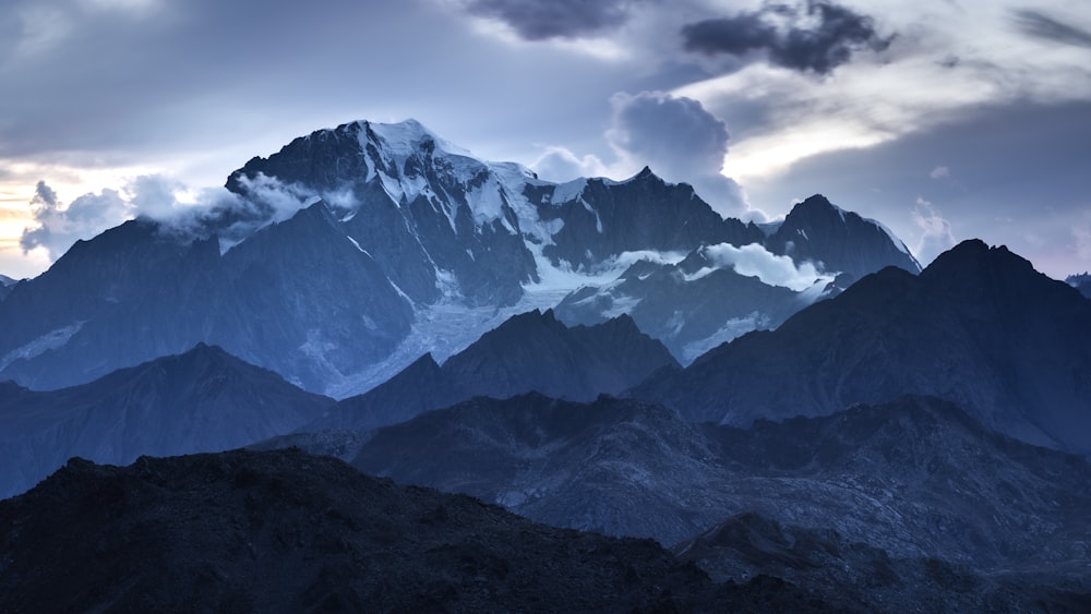 a very tall mountain with some clouds in the sky