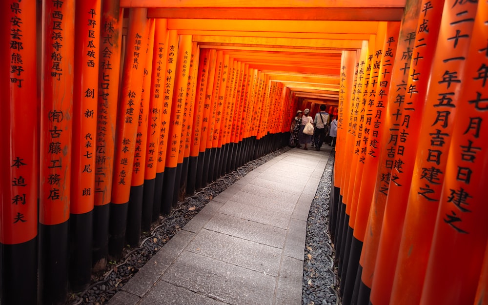 a walkway lined with orange and black columns