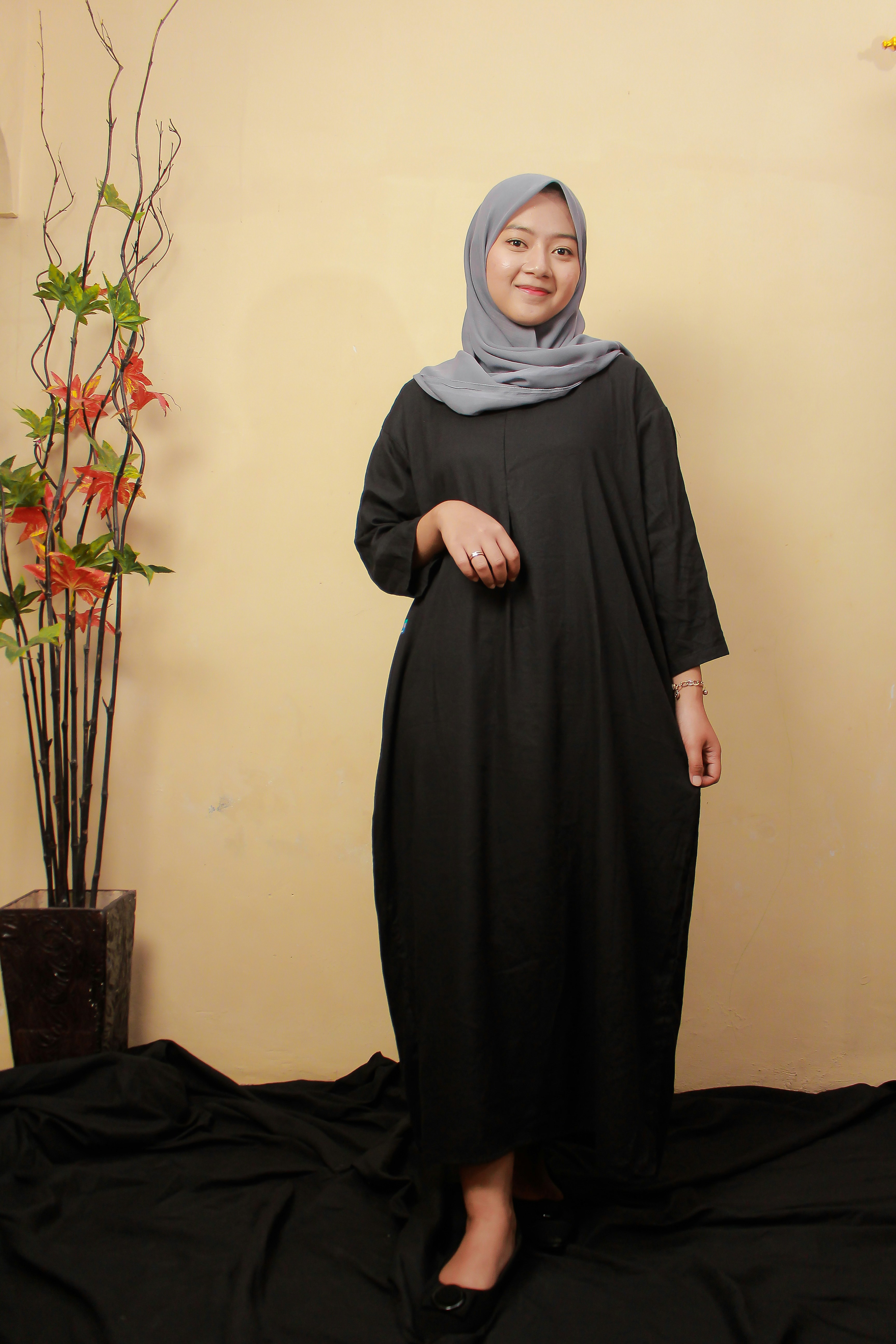 a woman standing in front of a plant