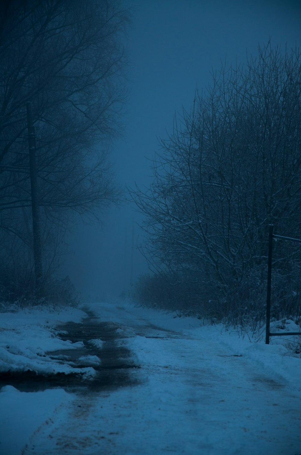 a snowy road with a stop sign in the middle of it