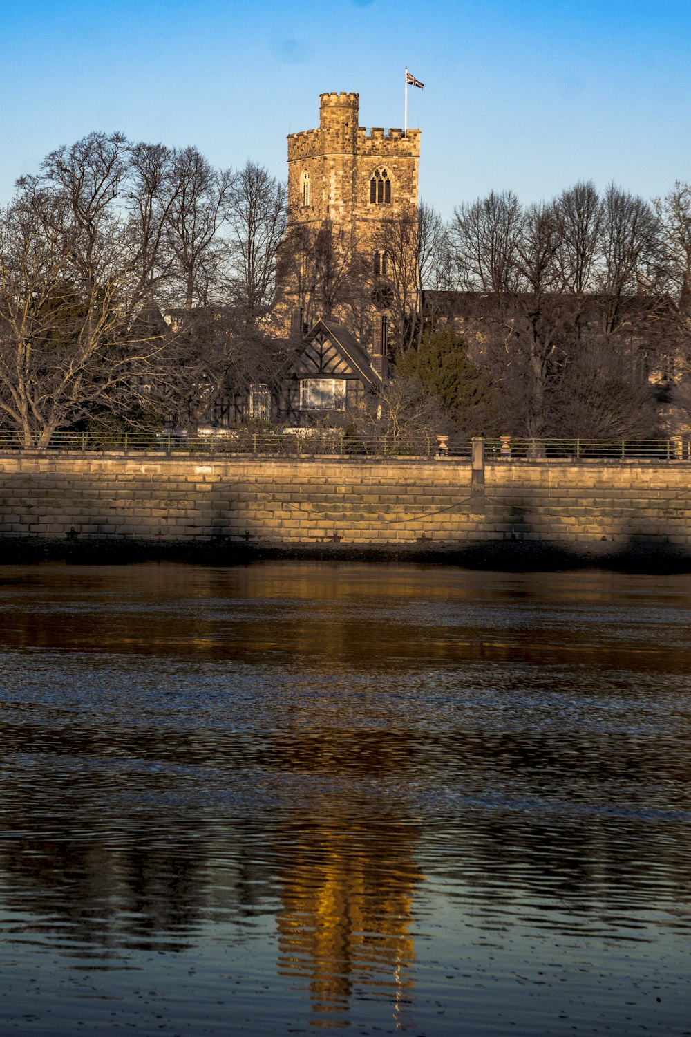 a river with a bridge and a castle in the background