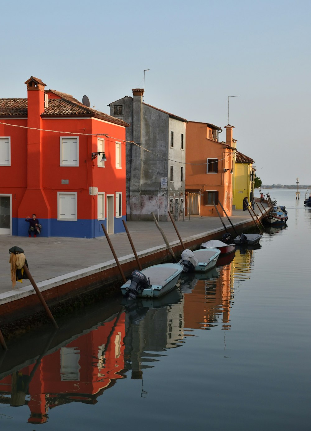 a row of boats sitting next to a red building