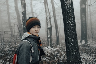 a person standing in the woods with a backpack
