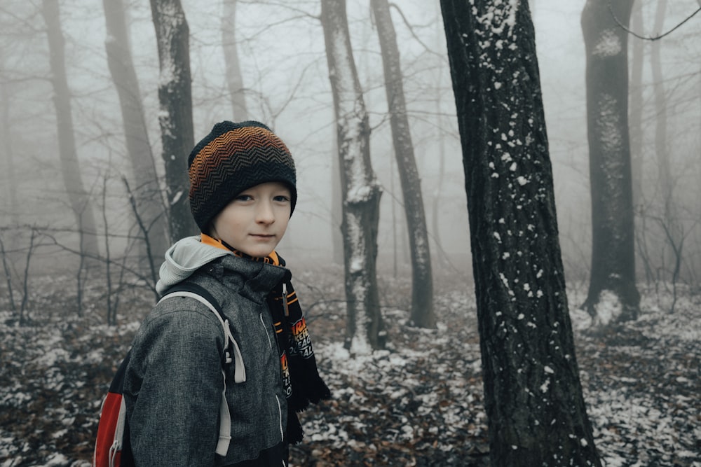 une personne debout dans les bois avec un sac à dos